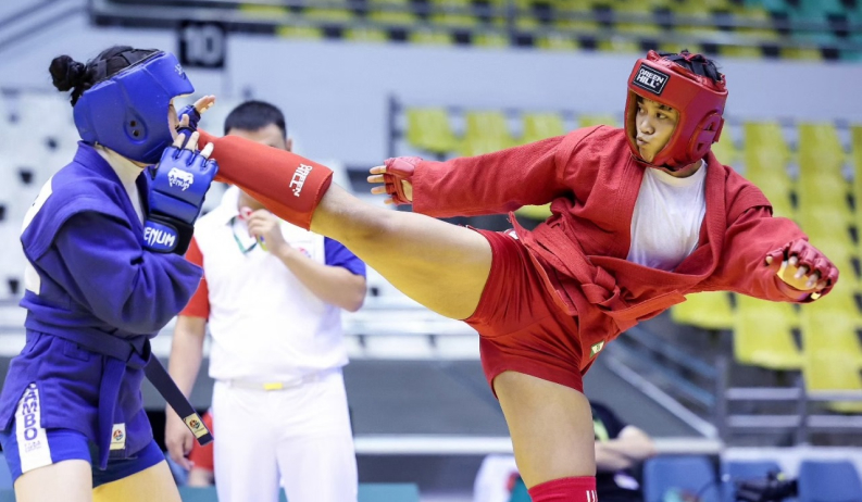 Atletas competindo no Sambo de Combate com capacetes e luvas