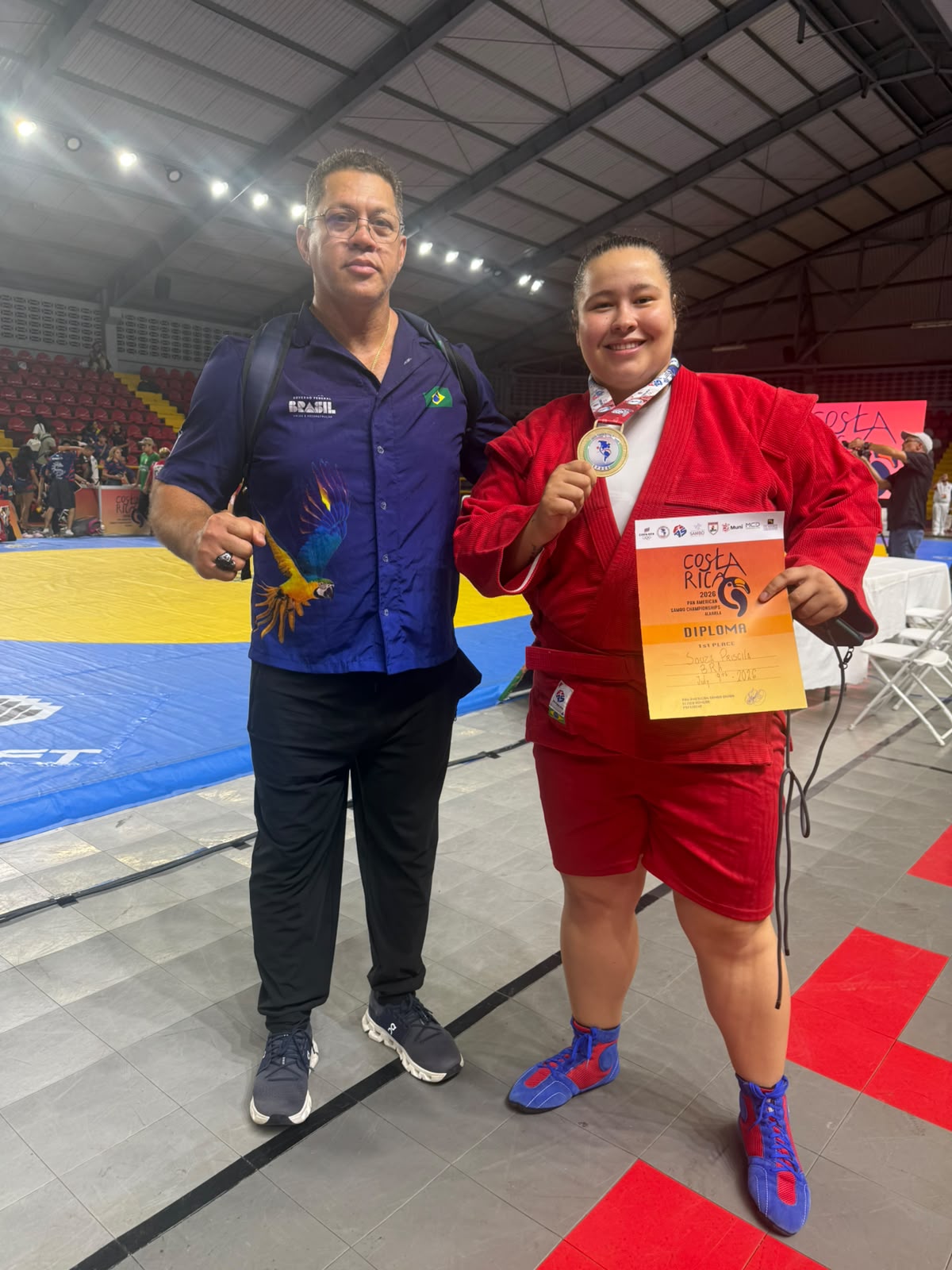 Atleta Priscila Rodrigues segurando sua medalha de ouro de tricampeã Pan-Americana